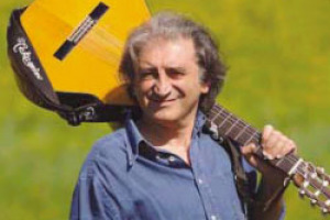 UNA CHITARRA ED UN BICCHIERE PER BRINDARE CON LE NOTE. LE NUOVE CANZONI DEL VINO SONO FIRMATE DA PAOLO FROLA, MEDICO E CANTAUTORE ALLIEVO DI LAUZI E GIACOMO BOLOGNA