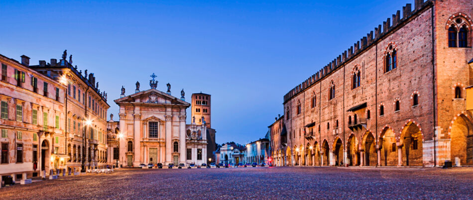 Sordello square at sunset in Mantova’s downtown illuminated and empty. Historic landmarks from palaces to churches and castle towers.